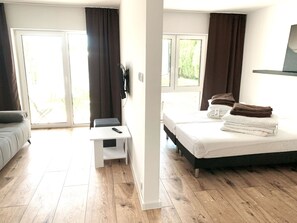 Et moderne hotelværelse med seng, skrivebord og sofa.
