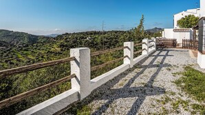 Un bâtiment blanc avec un chemin de gravier et une clôture en bois.