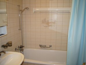 Ein Badezimmer mit einer Badewanne, einer Dusche und einem Waschbecken.