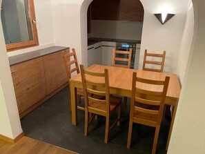 Eine kleine Küche mit Essbereich, Holzschränken und einem eingebauten Backofen.