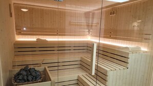 Un sauna avec des bancs en bois et une paroi en verre.