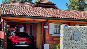 A red car parked in a garage with a red tiled roof and a stone wall. - Uns Hüsung by Interhome (Rerik)
