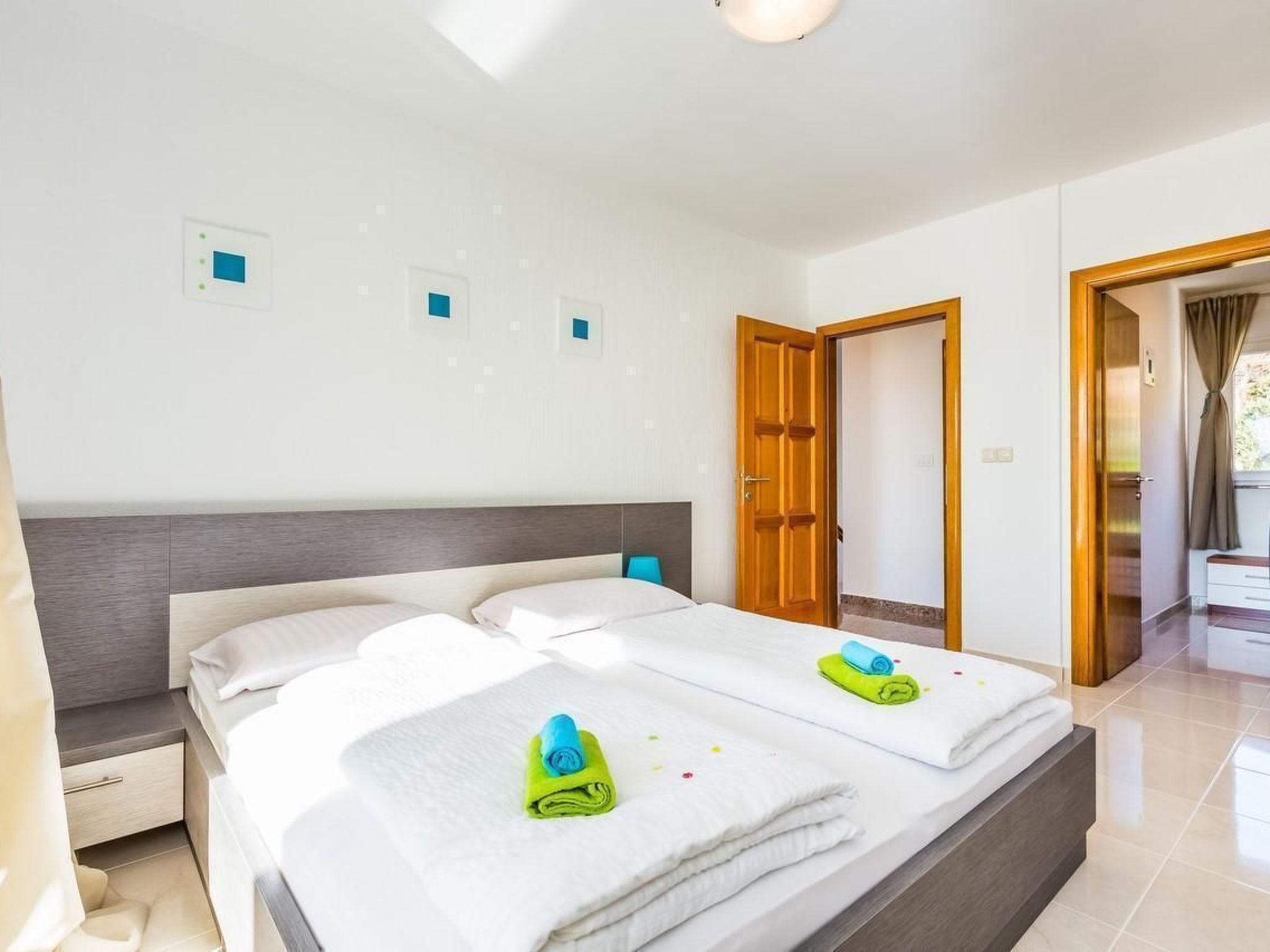 Une chambre d’hôtel avec deux lits, une porte en bois et une vue sur l’extérieur.
