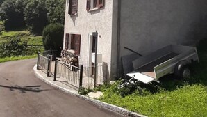 A two-story building with a sloped roof, a stone foundation, and a paved driveway. - 'Cà da Rör' mit Bergblick by Interhome (Acquarossa)