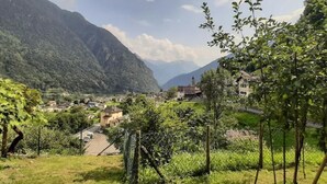 A mountainous village with traditional houses, a church, and lush greenery. - 'Cà da Rör' mit Bergblick by Interhome (Acquarossa)