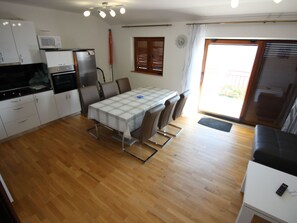 A compact kitchen with a dining table, chairs, and a microwave. - "Manda3" mit Blick auf das Wasser by Interhome (Novi Vinodolski)