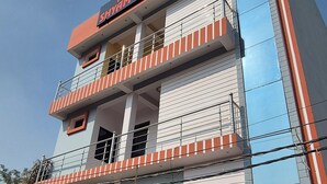 Un hôtel à plusieurs étages, reconnaissable à son enseigne bien visible indiquant « Hôtel Shyam Villa ».