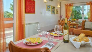 Ein Essbereich mit einem Tisch für zwei Personen, komplett mit Speisen, Weingläsern und einer Weinflasche.