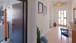 A hallway with a door, a hanging decorative item, a potted plant, and a chair. - Haus in Pula mit privatem Pool by Interhome (Pula)