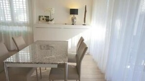 A dining area with a glass-top table, metal chairs, and a white interior. - Residenza San Materno Apt. 3 by Interhome (Ascona)
