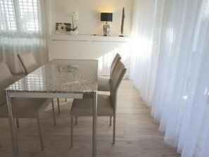 A dining area with a glass-top table, metal chairs, and a white interior. - Residenza San Materno Apt. 3 by Interhome (Ascona)