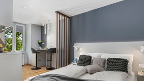 A modern bedroom with a bed, bedside tables, and a desk area with a chair. - Wohnung "InCenter Wohnung 2" by Interhome (Rijeka)