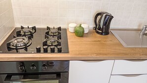 Ett kök med en gasspis, ugn och en kaffebryggare.