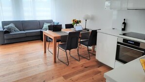 A modern kitchen with a dining area, a sofa, and a laptop on the table. - Panorama Locarno by Interhome (Locarno)