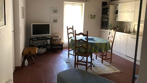 A cozy dining area with a table and chairs, a television, and a kitchen in the background. - Zwischen Locarno und Ascona ganze Wohnung by Interhome (Locarno)