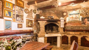 Un interno rustico da pub con pareti in mattoni a vista, panche di legno e un camino in muratura.
