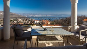 Un balcone con vista su una città e montagne.