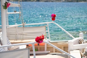 A boat deck with white railings, a white chair, and a small table. - Thodoroulis in Paxi With 1 Bedrooms and 1 Bathrooms (Paxos)