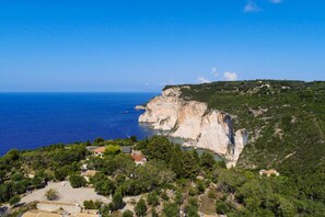 A coastal property with cliffside views, a small house, and surrounding greenery. - Thodoroulis in Paxi With 1 Bedrooms and 1 Bathrooms (Paxos)