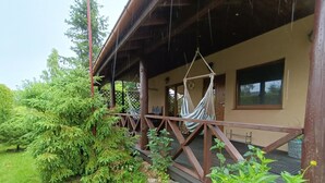 A wooden deck with hammocks and a covered area. - mit Jacuzzi by Interhome (Kopalino)