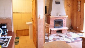 Eine Küche mit einem Gaskochfeld, einer Spüle und einem Kamin.