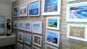 A wall with multiple framed photographs depicting various landscapes and seascapes. - Geräumige Ferienwohnung in Zingst mit Terrasse by Interhome (Ostseebad Zingst)