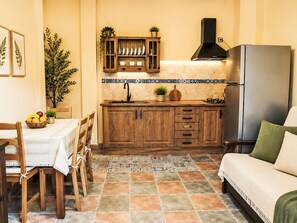 Eine kleine Küche mit Holzschränken, einem eingebauten Herd und einem Kühlschrank.