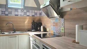 Una cucina moderna con finestra a lucernario, mobili in legno e uno schienale colorato.