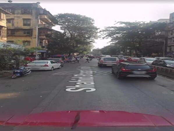 A street with parked cars and a designated bike lane. - Hotel P A Residency (Mumbai)