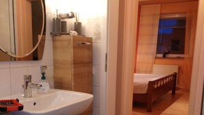 A modern bathroom with a large sink, mirror, and wooden cabinets. - Wohnung in Altengroden mit Garten by Interhome (Wilhelmshaven)