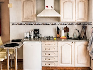 A compact kitchen with a refrigerator, a coffee maker, and a gas stove. - Apartment El Hierro by Interhome (El Paso)