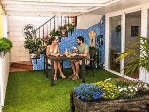 A patio with a table and chairs, surrounded by potted plants and a small garden area. - Apartment El Hierro by Interhome (El Paso)