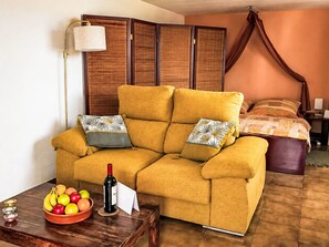 A room with a sofa, a table with fruit and a bottle, a bed with a canopy, and a lamp. - Apartment El Hierro by Interhome (El Paso)