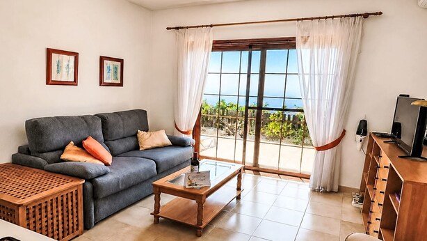 A living room with a sofa, coffee table, and a TV stand. - La Gomera by Interhome (El Paso)