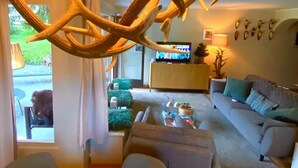 A modern living room with a large wooden antler sculpture, a sofa, a coffee table, and a television. - Chesa Ladina by Interhome (La Punt-Chamues-ch)
