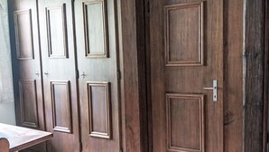 A set of wooden double doors with a classic design, a metal handle, and a keyhole.