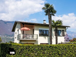 A two-story house with a balcony, a red umbrella, and a sign reading 'CASA Adelina.' - Casa Adelizia by Interhome (Ascona)