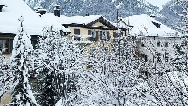 A snow-covered residential area with houses and a mountain backdrop. - Chesa Maura by Interhome (Celerina)