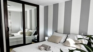 A hotel room with a bed, a nightstand, a mirror, and a plant. - Casa Gaetano by Interhome (Balestrate)