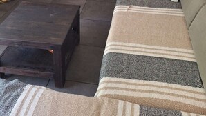 En stue med fjernsyn, sofa og en lille Buddha-figur.