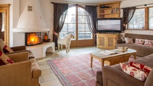 Una sala de estar acogedora con chimenea, televisor y un perro.