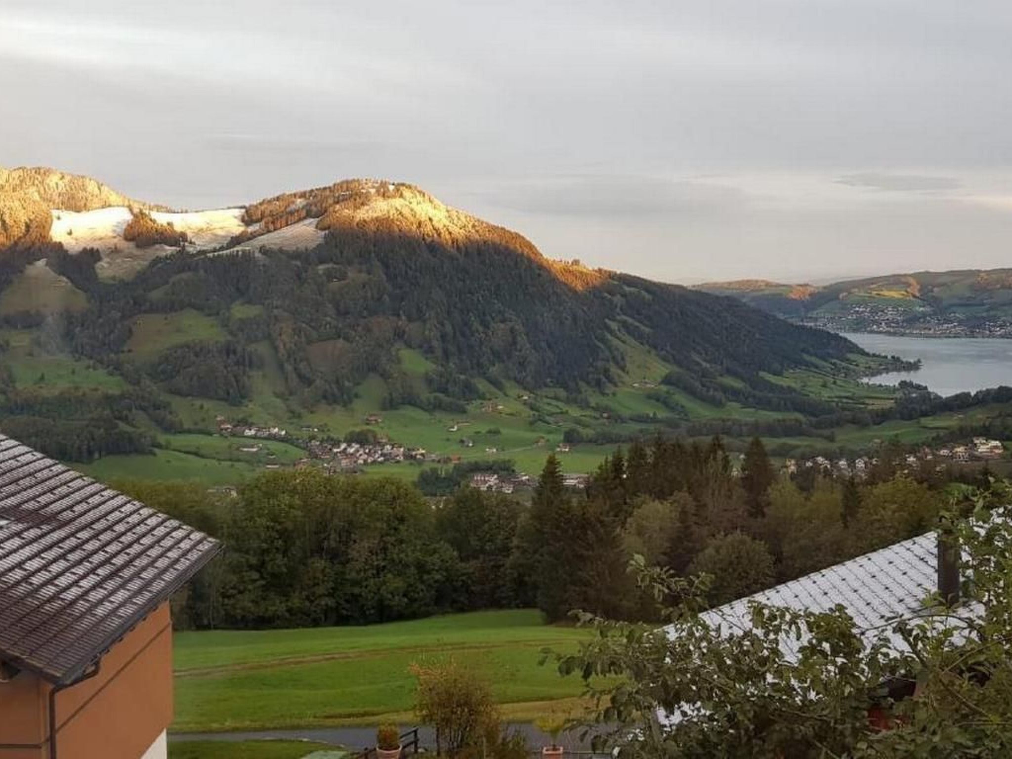 Vista de un paisaje montañoso con un lago y un pueblo.