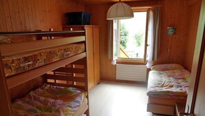 A room with bunk beds, a window with curtains, and a radiator. - Des Alpes 4-Bettwohnung by Interhome (Hasliberg)