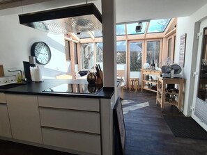 Een koelkast, een oven, een vaatwasser, kookgerei, borden en bestek