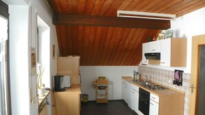 Una cocina compacta con armarios de madera, microondas, estufa y lavamanos.