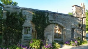 Un edificio de piedra con arcos y enredaderas.