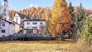 A town with a prominent clock tower, a gazebo, and autumn-colored trees. - Studio Chesa Marias by Interhome (Sils Maria)