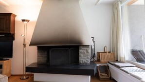 A modern living room with a fireplace, a television, and a large window.