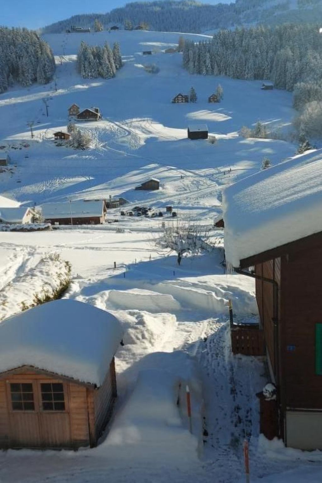 A snow-covered village with wooden houses and a clear sky.