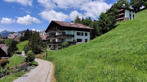 A two-story house with a balcony, surrounded by greenery and a clear sky. - im Gründli by Interhome (Wildhaus)